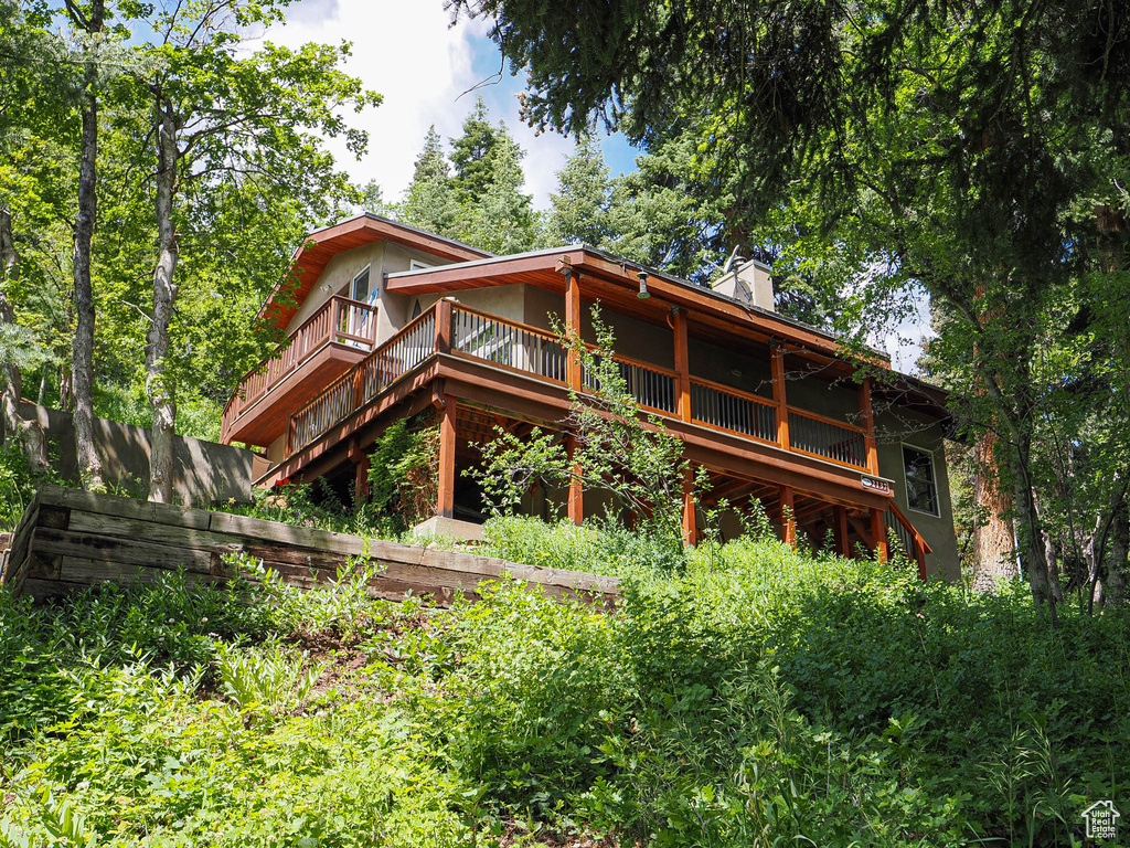 Back of property featuring a chimney and a deck