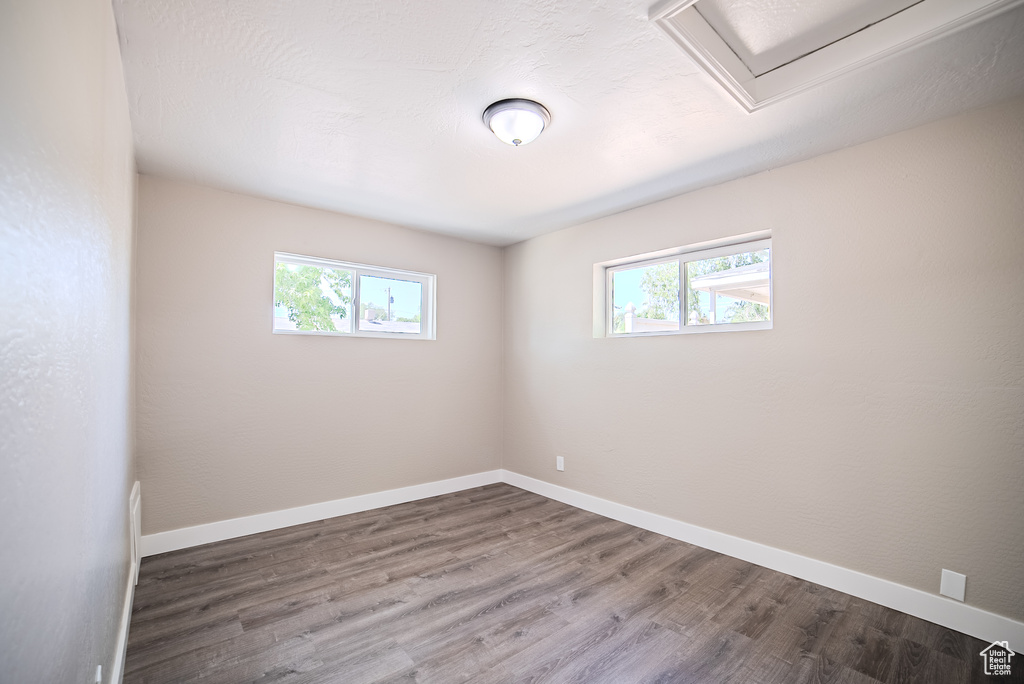 Unfurnished room featuring plenty of natural light and wood finished floors