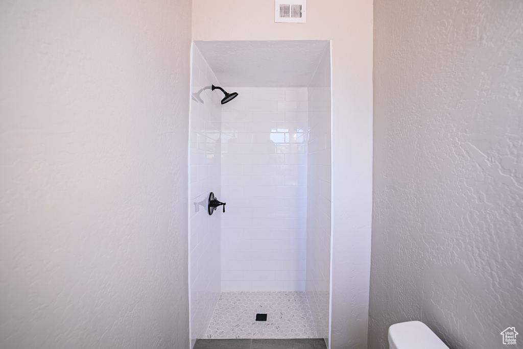 Full bath with toilet and a shower stall