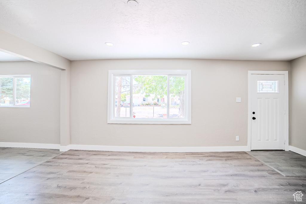 Entryway featuring healthy amount of natural light, wood finished floors, and recessed lighting