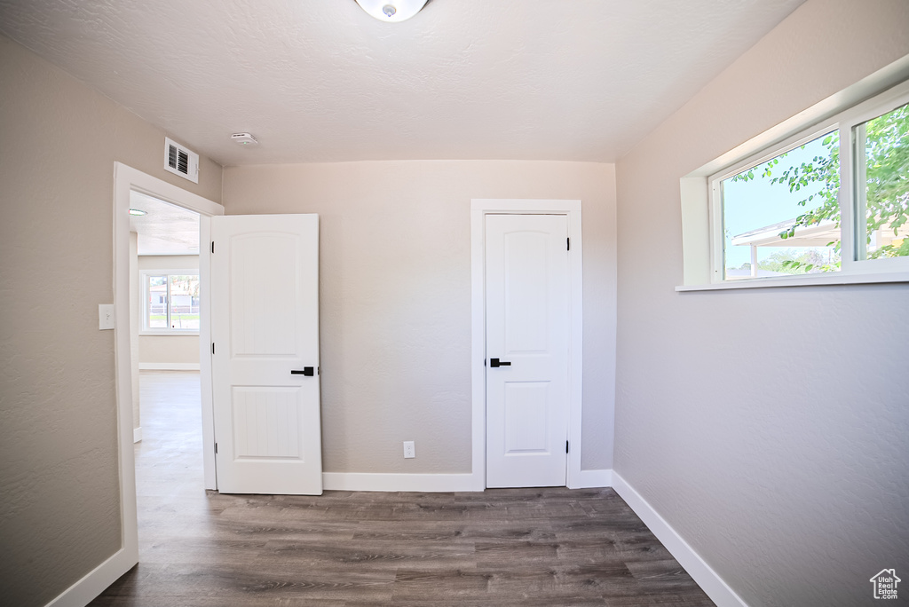 Unfurnished bedroom featuring dark wood finished floors and baseboards