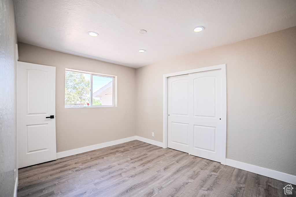 Unfurnished bedroom with wood finished floors, a closet, and recessed lighting