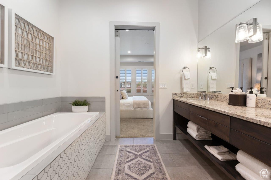 Ensuite bathroom featuring vanity, a garden tub, and tile patterned floors