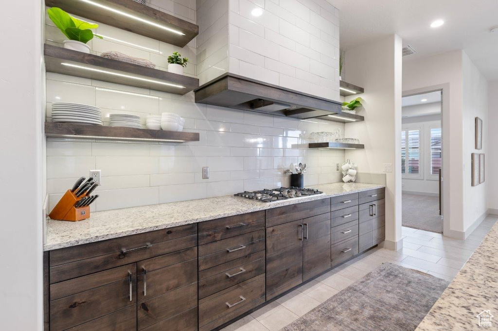 Kitchen featuring open shelves, stainless steel gas stovetop, tasteful backsplash, light tile patterned floors, and recessed lighting