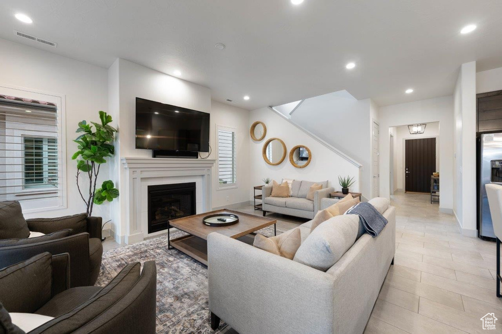 Living area with recessed lighting, a fireplace, and light tile patterned floors
