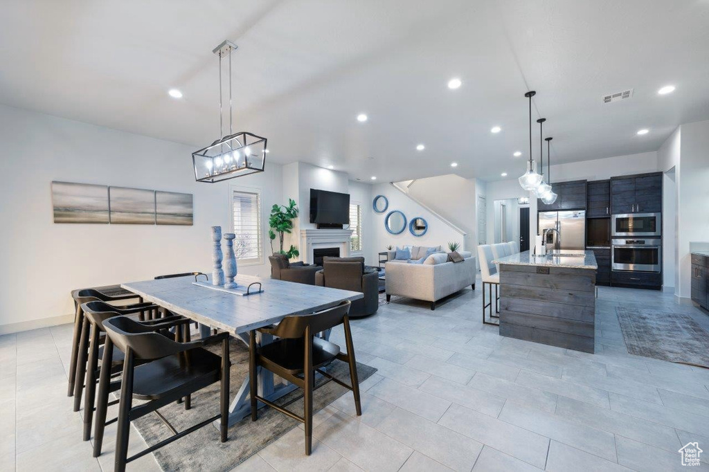 Dining area featuring recessed lighting, a fireplace, and light tile patterned floors