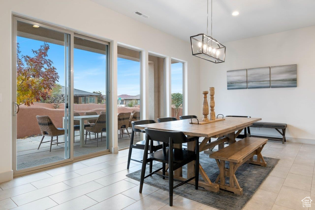 Dining area with a chandelier, light tile patterned floors, and recessed lighting