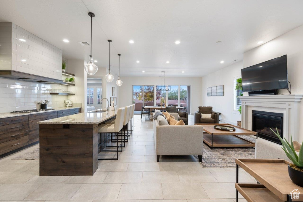 Living room featuring recessed lighting, a fireplace, and light tile patterned flooring