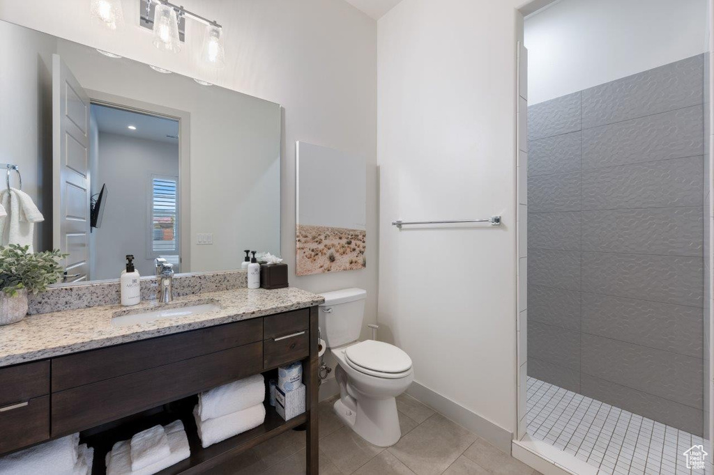 Full bathroom with vanity, walk in shower, and tile patterned flooring