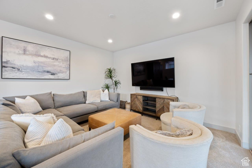 Living area with light carpet and recessed lighting