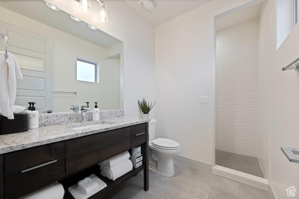 Full bathroom with vanity, walk in shower, and tile patterned flooring