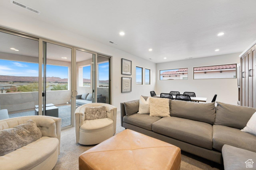 Living area with recessed lighting and light colored carpet