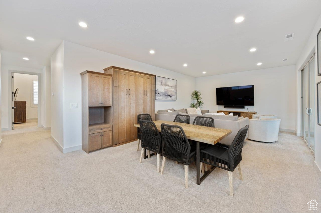 Dining space with recessed lighting and light carpet