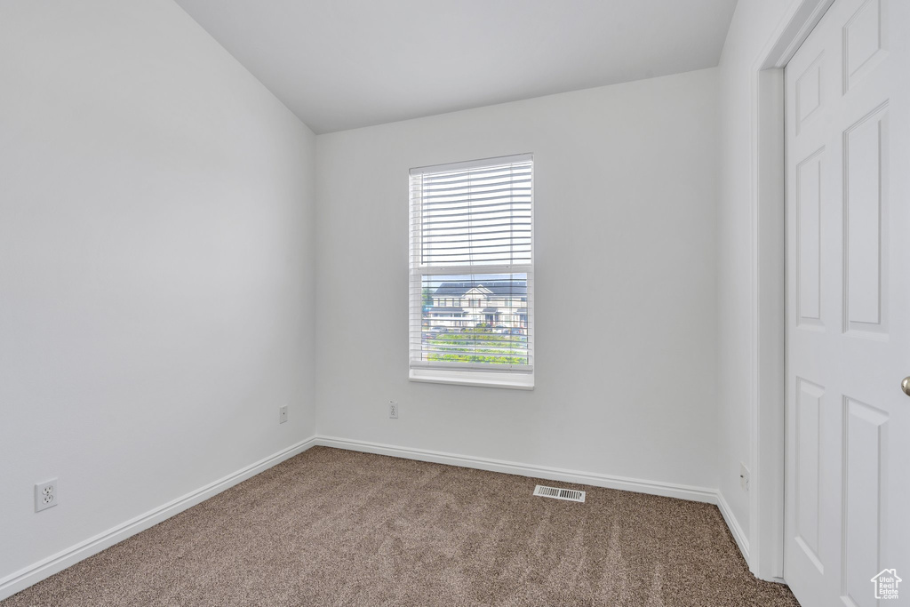 Empty room featuring carpet and baseboards