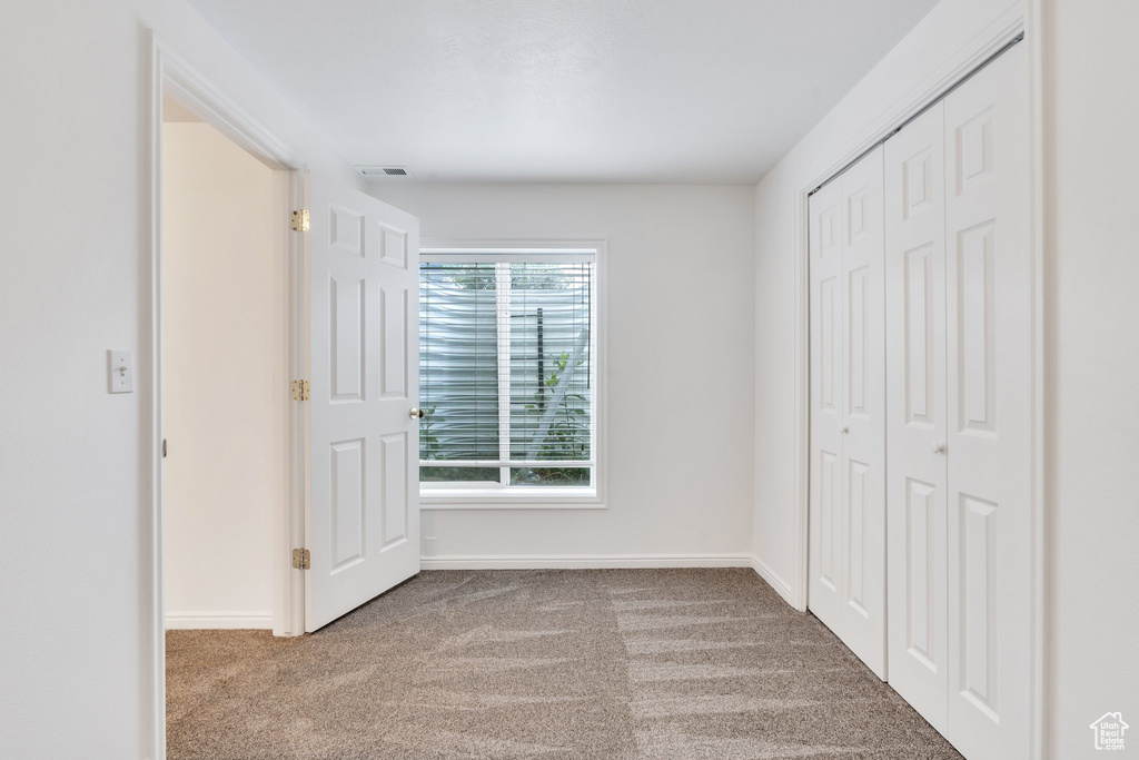 Unfurnished bedroom featuring carpet and a closet