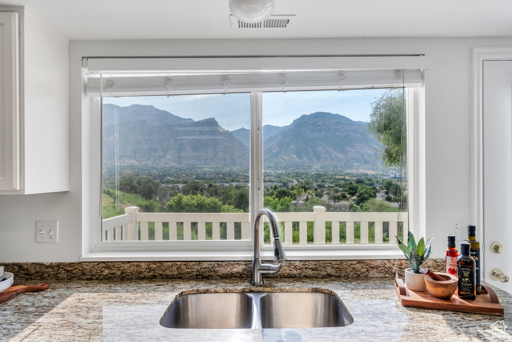 Kitchen view of stone counters and white cabinets