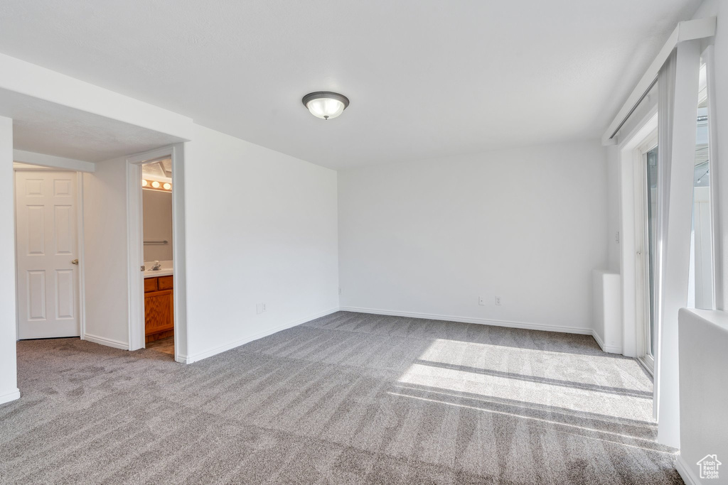 Empty room featuring carpet and baseboards