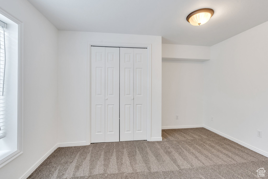Unfurnished bedroom featuring carpet floors and a closet