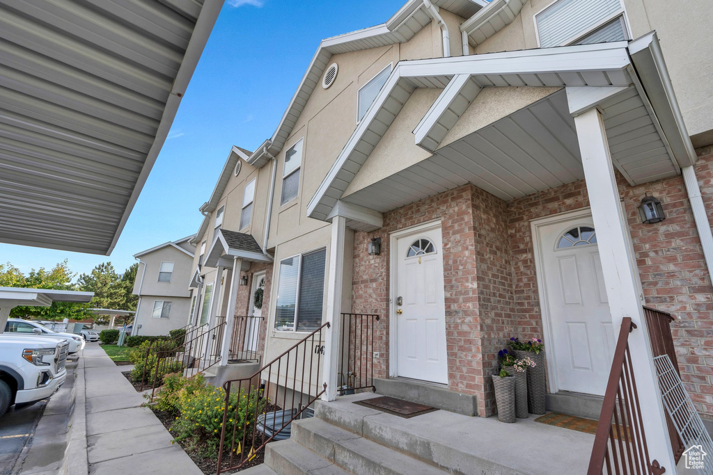 View of exterior entry featuring stucco siding and brick siding