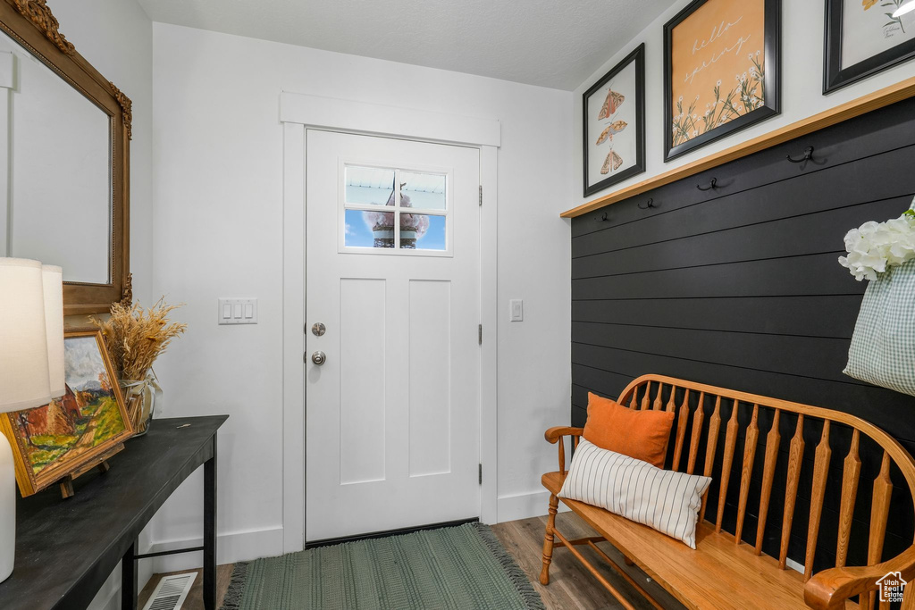 Entrance foyer with baseboards and wood finished floors