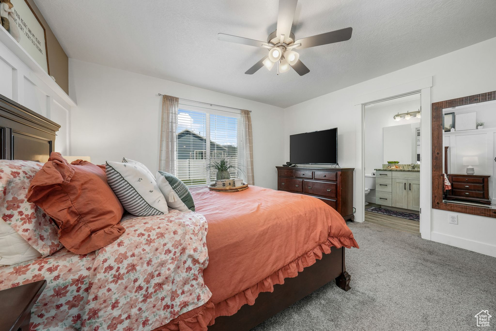 Bedroom featuring light carpet, a ceiling fan, and connected bathroom