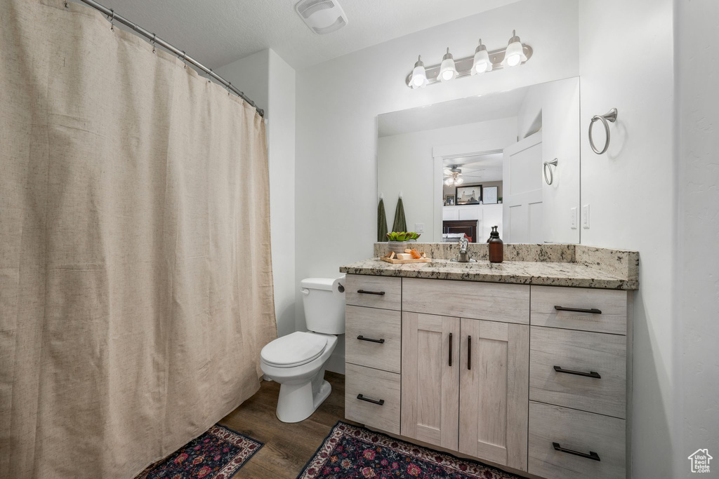 Full bath with wood finished floors, vanity, and a ceiling fan