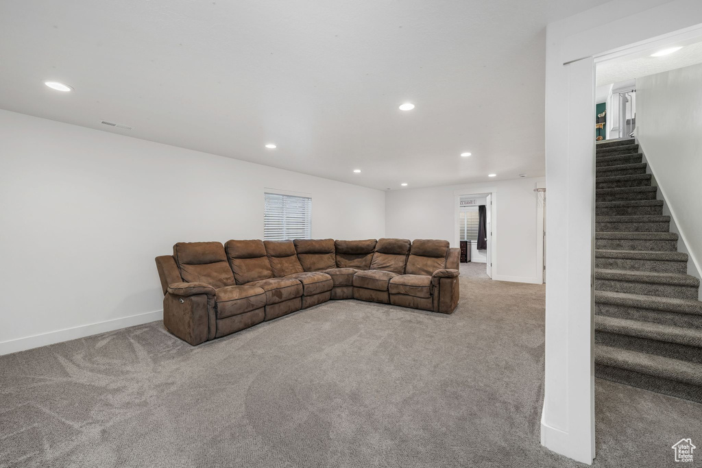 Living room featuring recessed lighting, carpet floors, and stairway