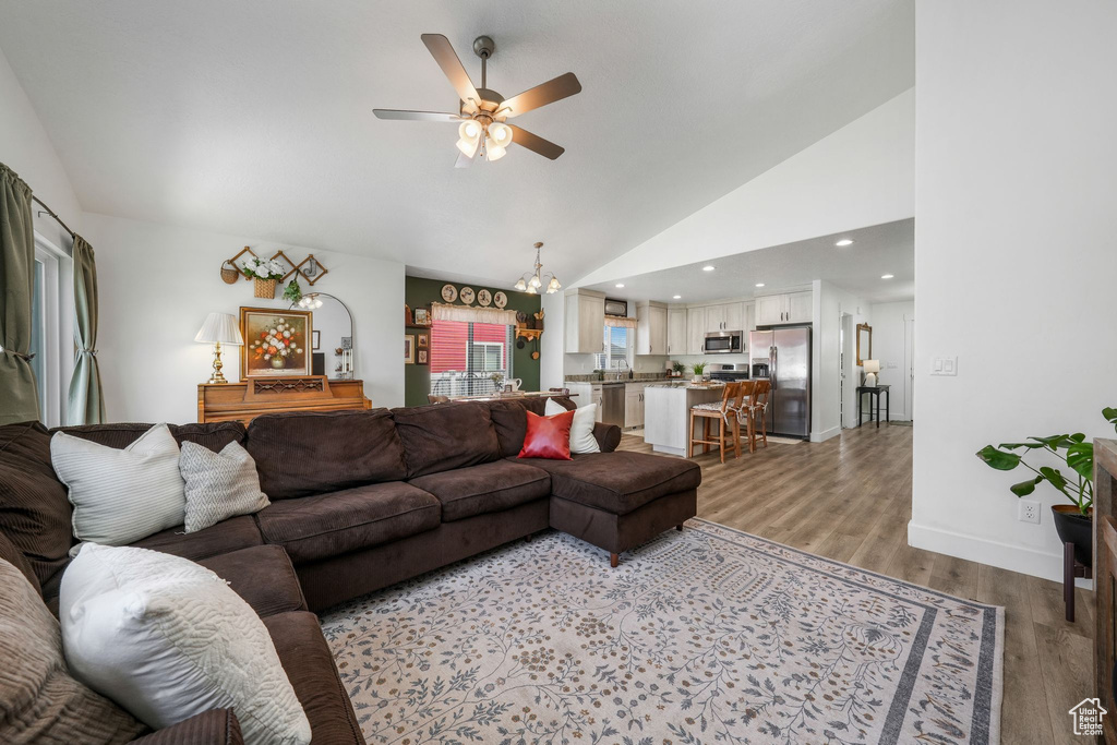 Living room featuring ceiling fan, light wood-style floors, high vaulted ceiling, and recessed lighting