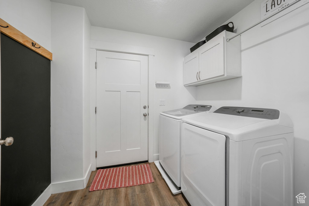Laundry area with cabinet space, washing machine and dryer, and dark wood-type flooring