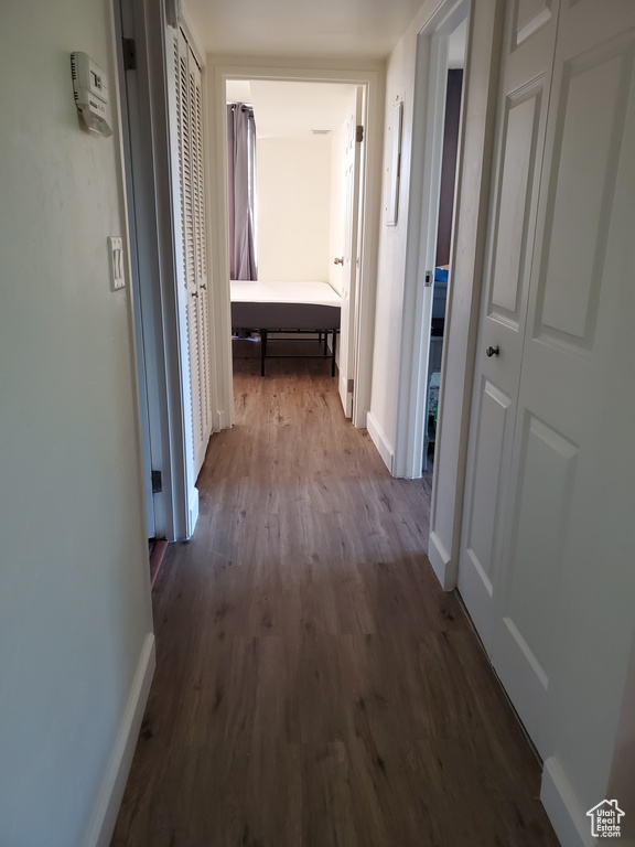 Hall with dark wood finished floors and baseboards
