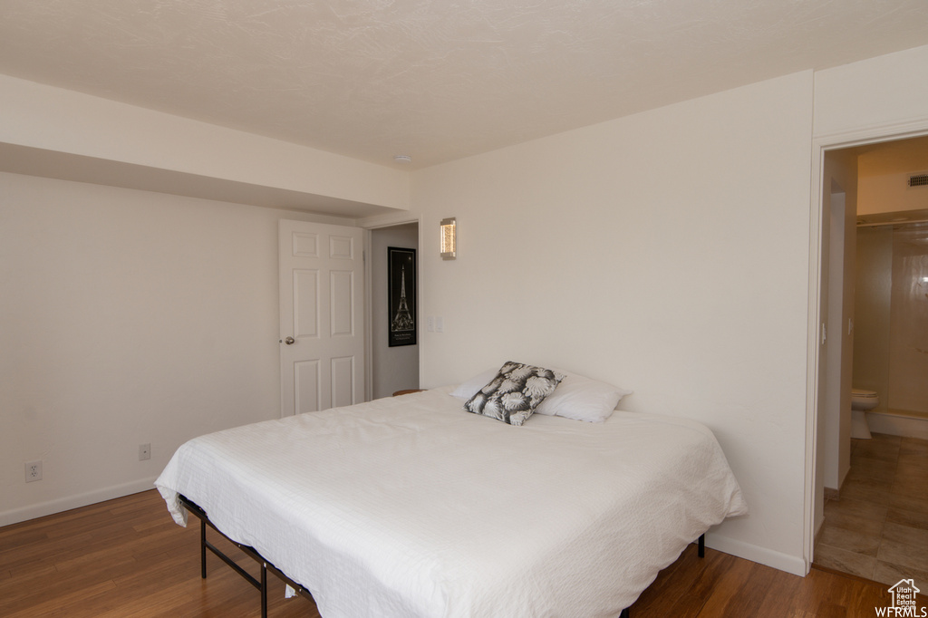 Bedroom with baseboards and wood finished floors