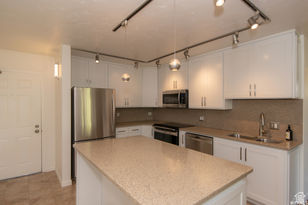 Kitchen with stainless steel appliances, rail lighting, and white cabinets