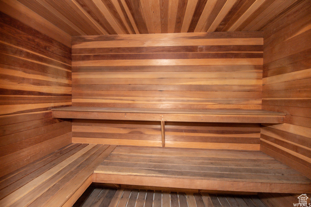 Sauna / steam room featuring wooden ceiling and wooden walls
