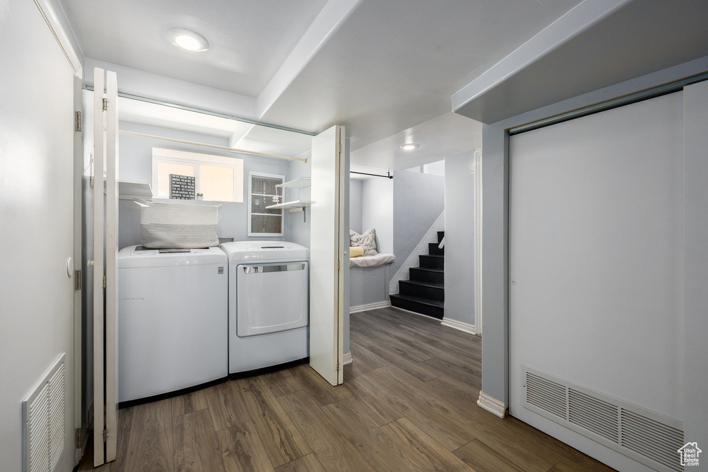 Laundry room with washer and dryer, dark wood-type flooring, and recessed lighting