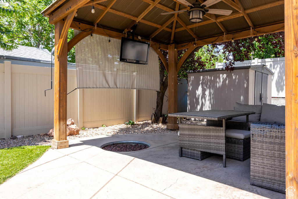Fenced backyard featuring a patio area, a gazebo, outdoor dining area, and ceiling fan
