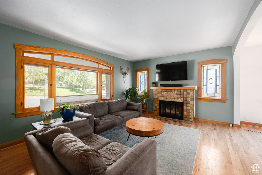 Living room with wood finished floors and a tile fireplace