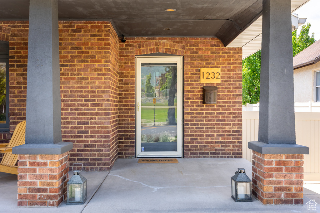 Doorway to property featuring brick siding