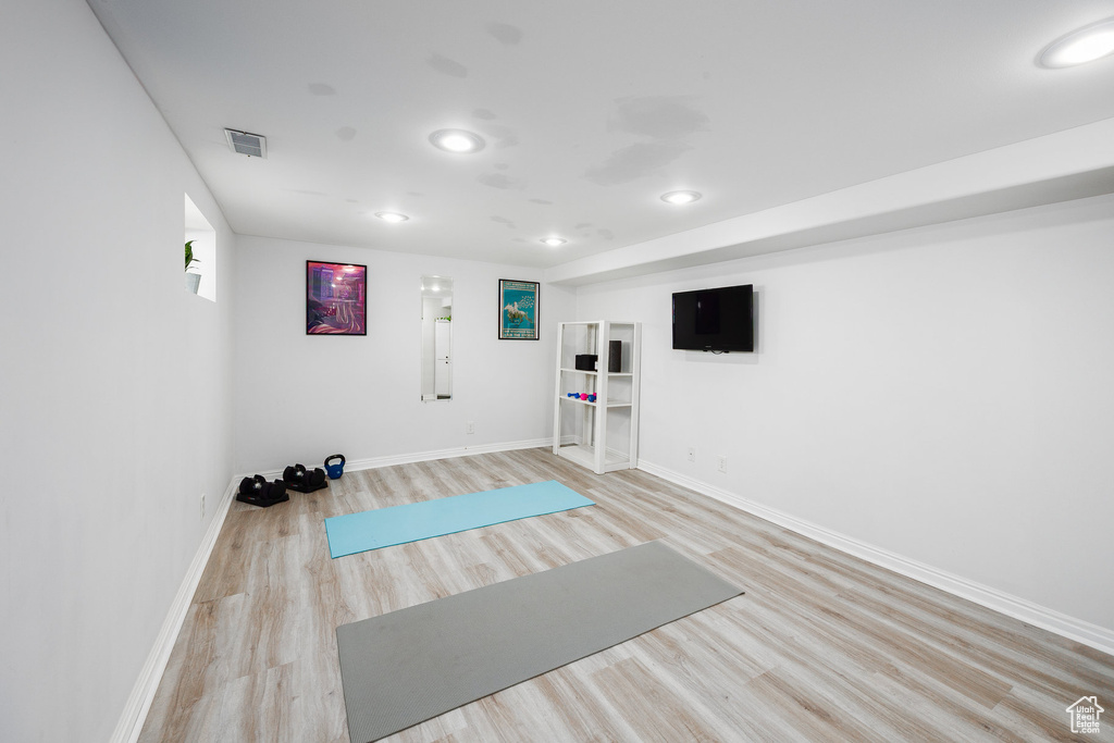 Workout room featuring light wood-style floors and recessed lighting