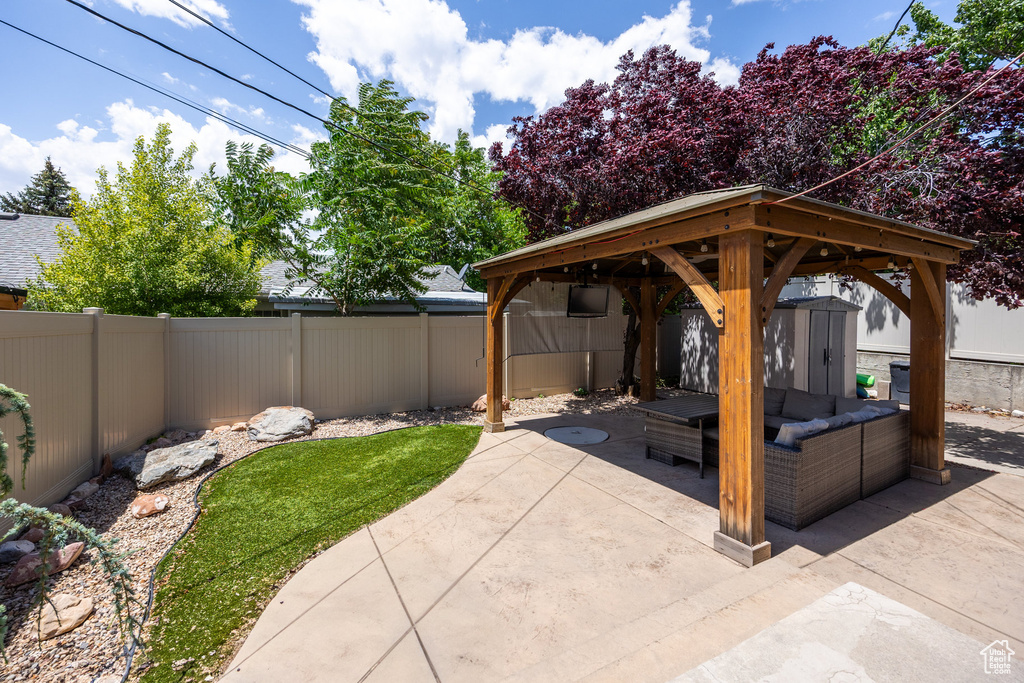 Fenced backyard featuring a patio area, a storage shed, and outdoor lounge area