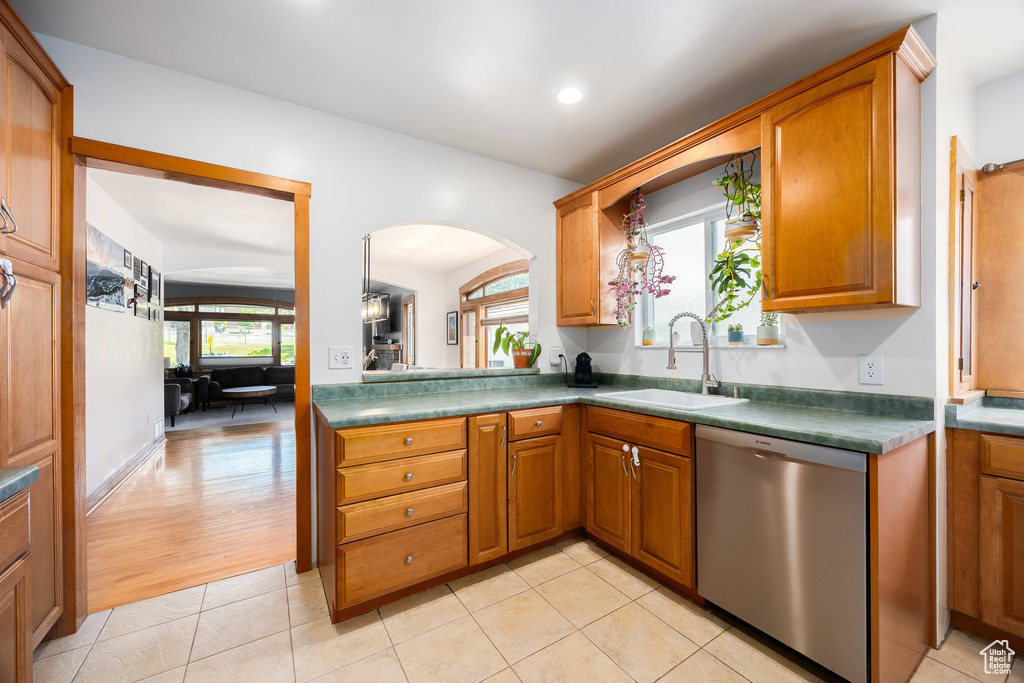 Kitchen featuring dishwasher, arched walkways, brown cabinets, and recessed lighting