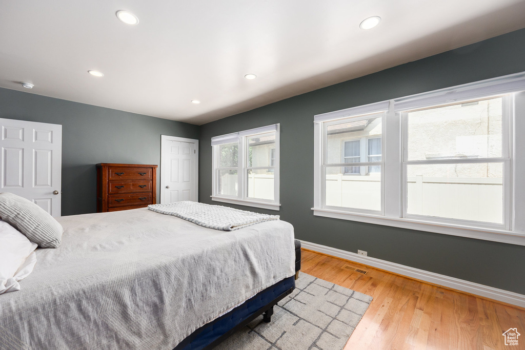 Bedroom with light wood-style floors, recessed lighting, and a closet