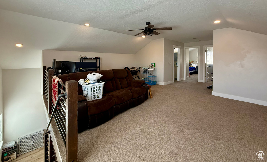 Living area with lofted ceiling, a ceiling fan, carpet flooring, and recessed lighting