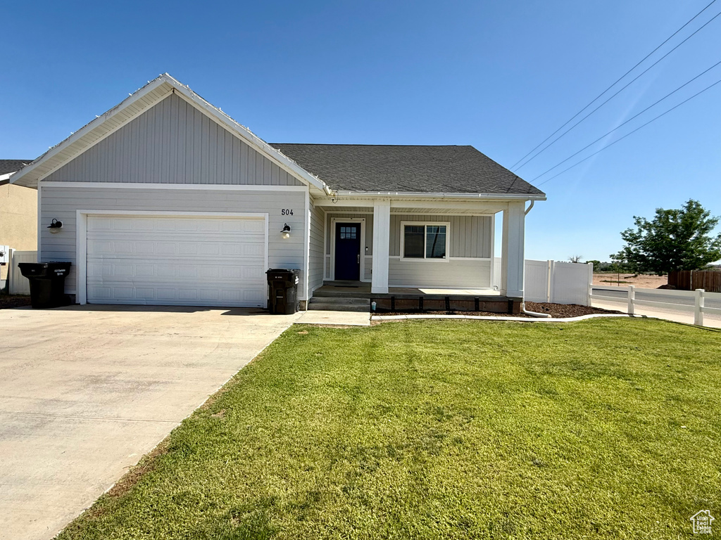 View of front of home featuring driveway, a garage, a porch, and a shingled roof