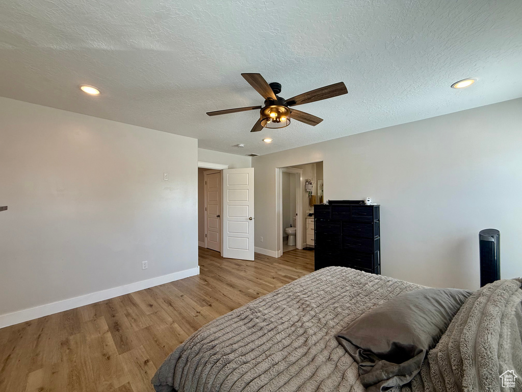 Bedroom featuring light wood-style floors, recessed lighting, ceiling fan, a textured ceiling, and connected bathroom