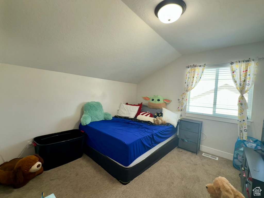 Bedroom featuring lofted ceiling and carpet floors