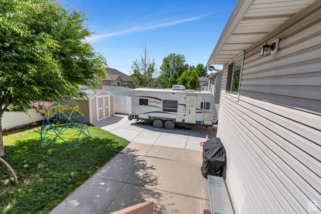 View of patio with a storage shed