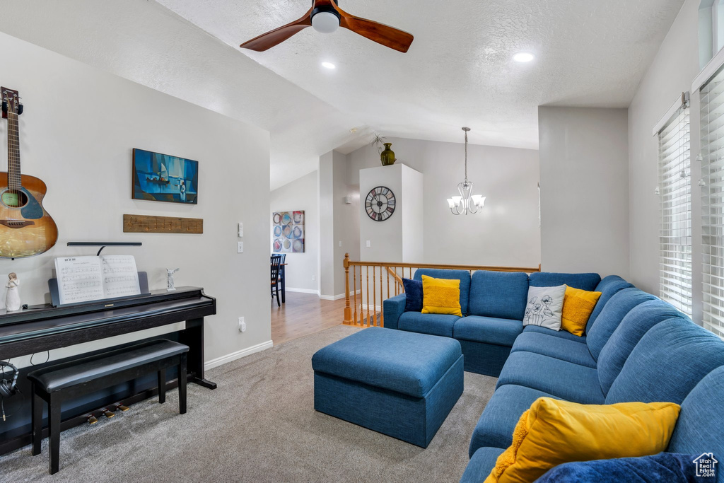 Carpeted living room with ceiling fan, lofted ceiling, a chandelier, and recessed lighting