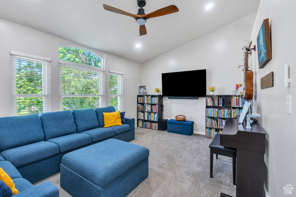 Carpeted living room featuring lofted ceiling, a ceiling fan, and recessed lighting