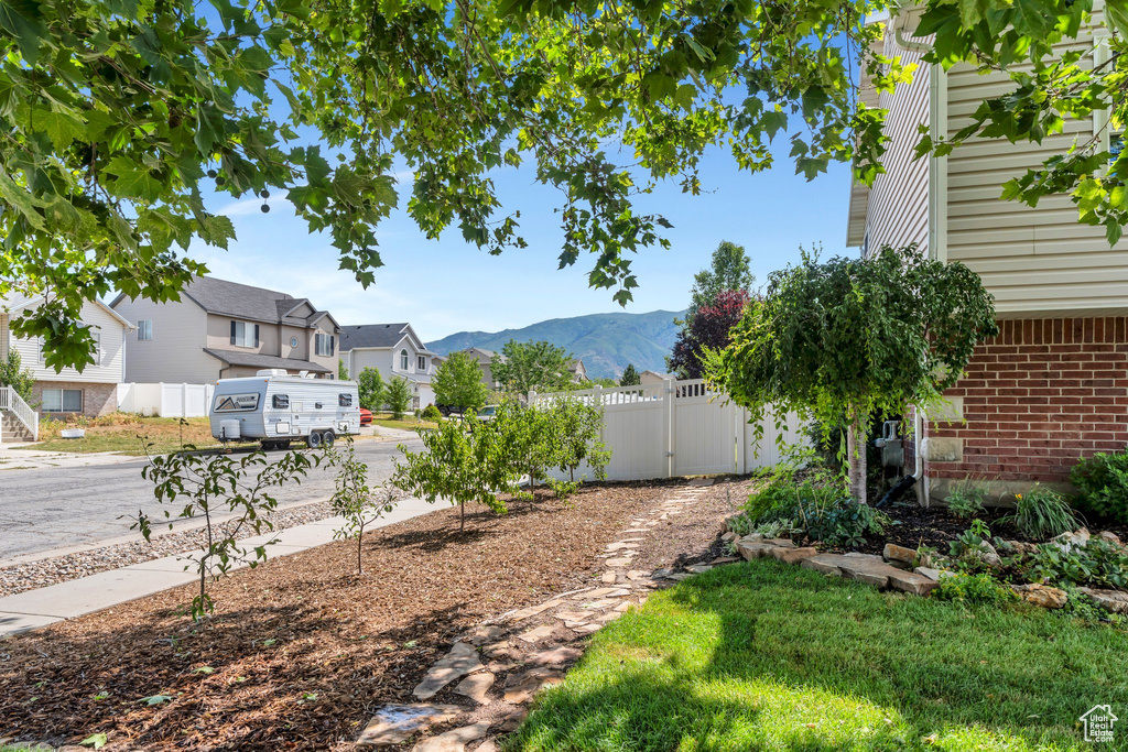 View of yard featuring a residential view, a mountain view, and a gate