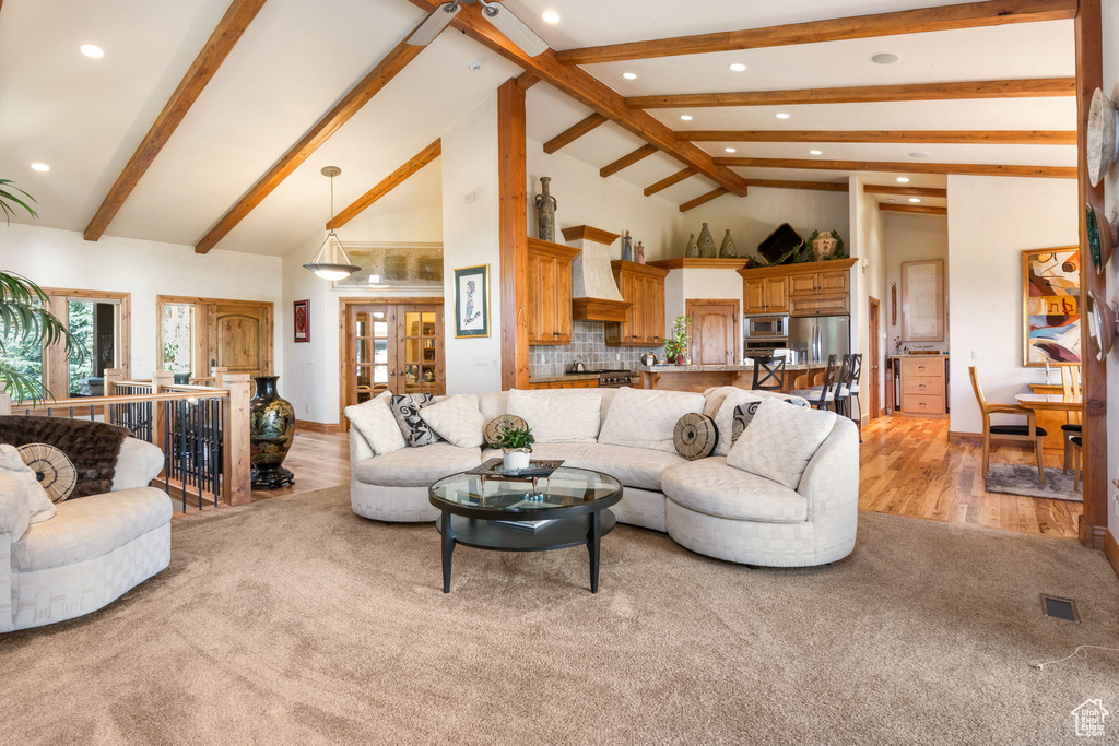 Living room with recessed lighting, beamed ceiling, light wood-type flooring, and high vaulted ceiling